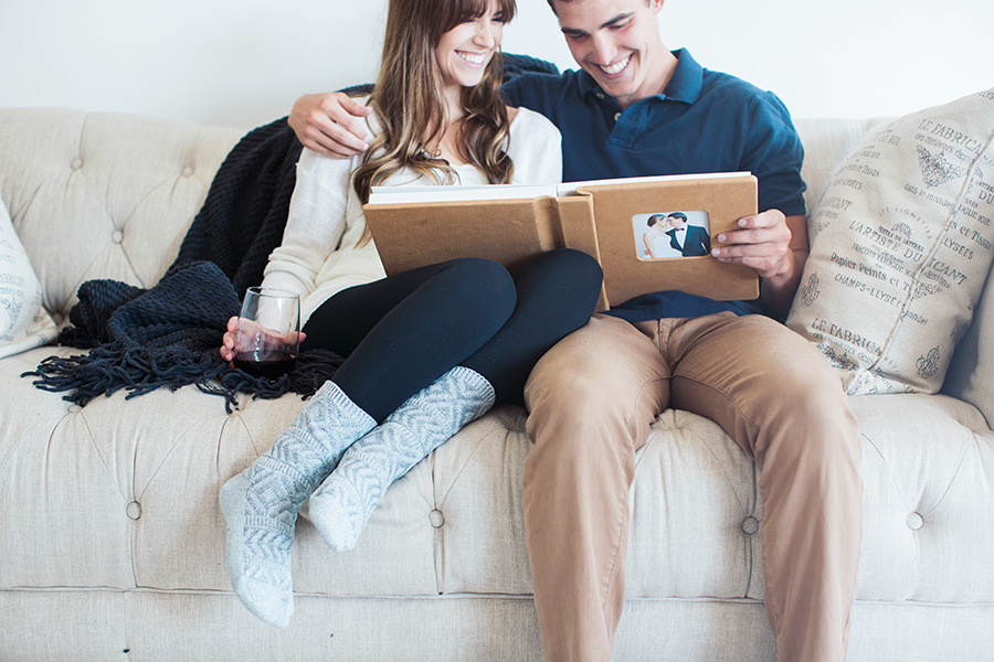 Align Legacy books with couple cuddling on couch looking at album 